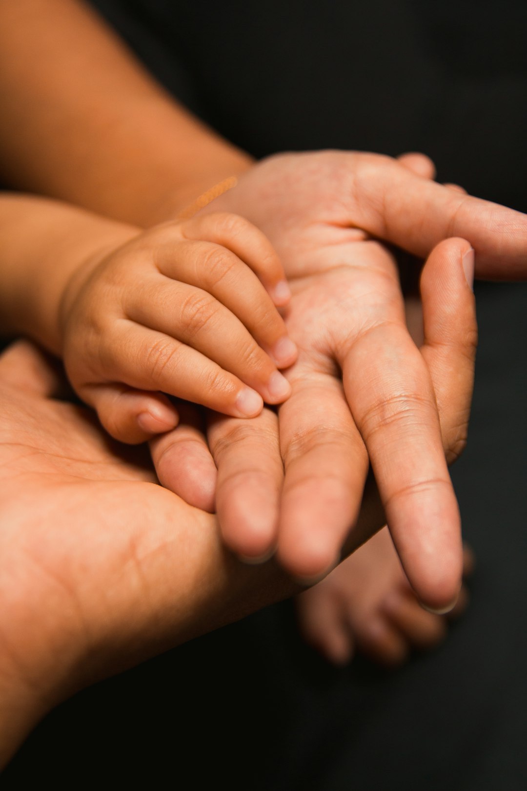 An adult and a child's hands together, a moment of care