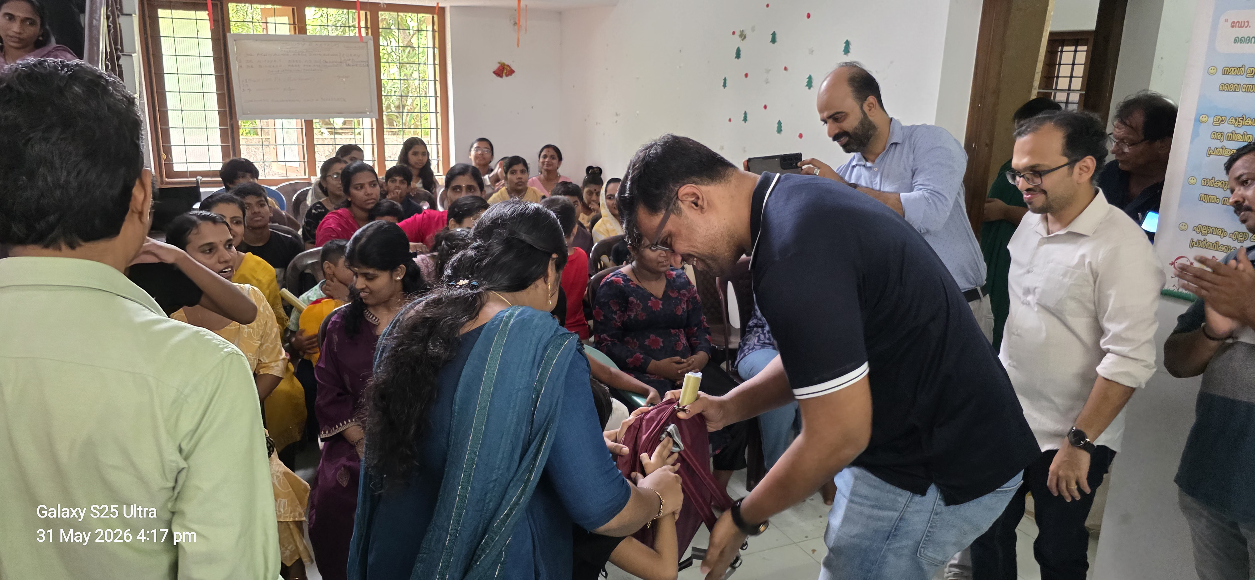 A school kit being handed to a child at a Society distribution event