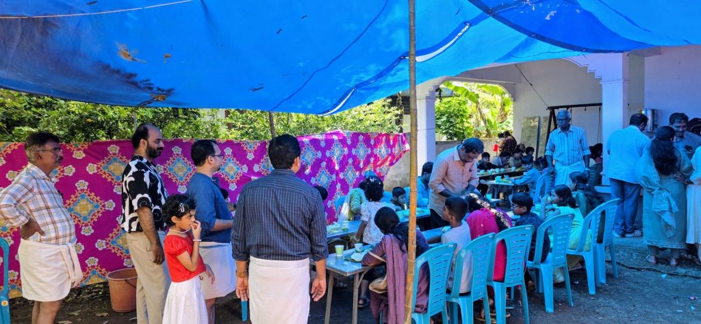 Families sharing a meal together under the pandal at the centre