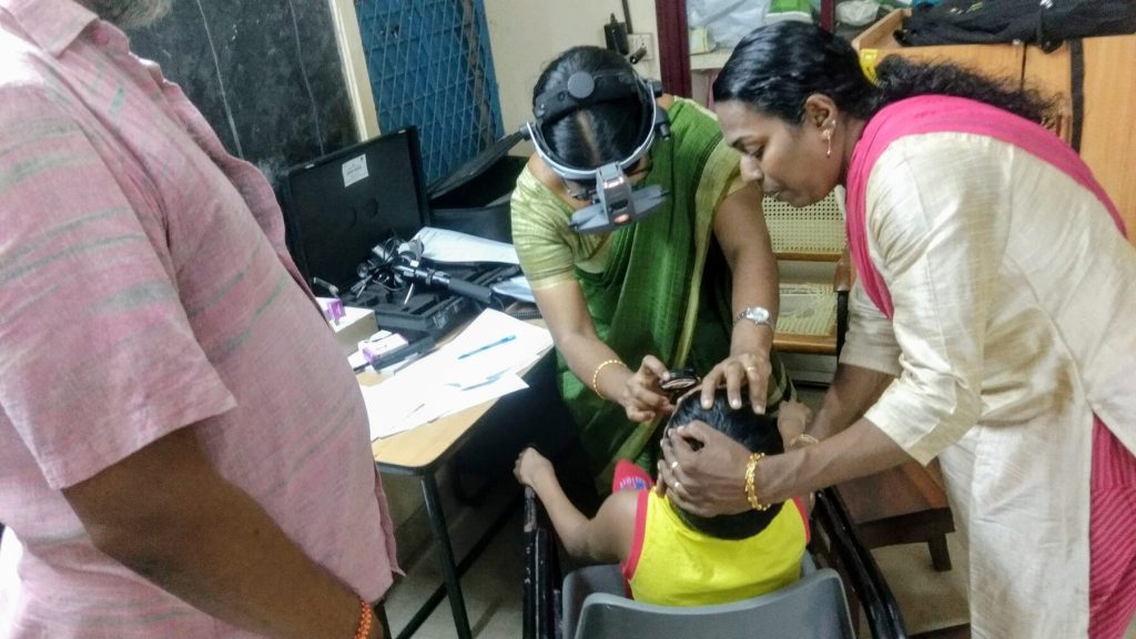 A child being examined by doctors at a free medical screening camp