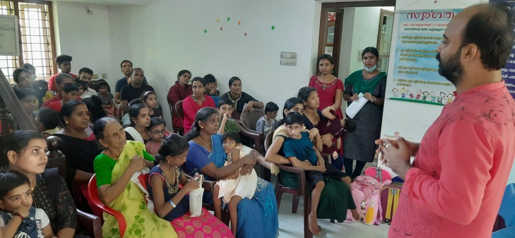 Parents and children at a meeting in the guidance centre hall, May 2023