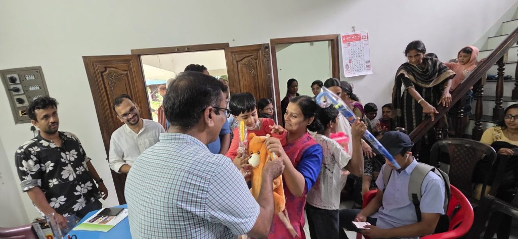 Handing over school kits to children at the Back to School programme, May 2025